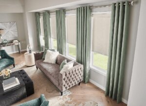 Beautiful sea foam green fabric drapes add color and drama to this living space birmingham